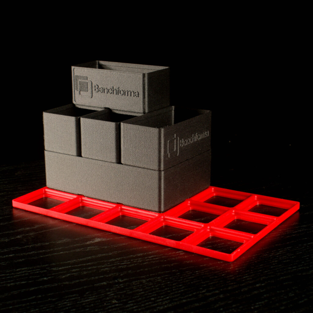 Benchforma branded Gridfinity Bins stacked on TPE baseplates, Benchforma Modular Systems Logo embossed on the bins