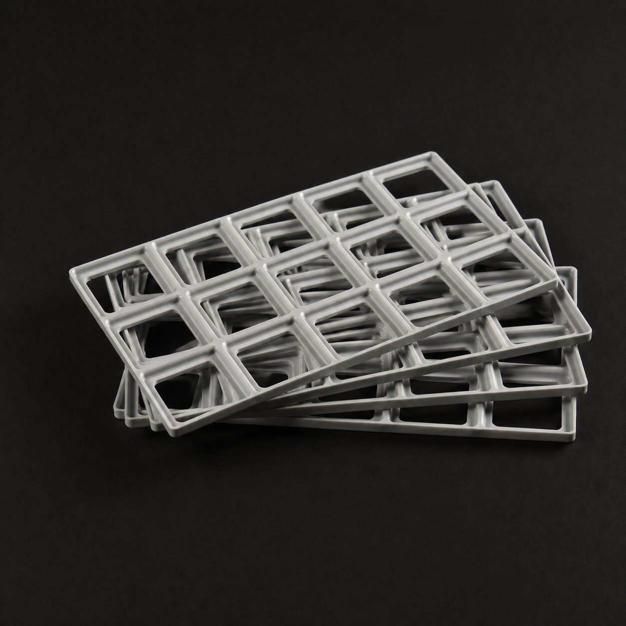 Stack of 4 Slate Gray Benchforma TPE Baseplates, indicating the shape and size of the product