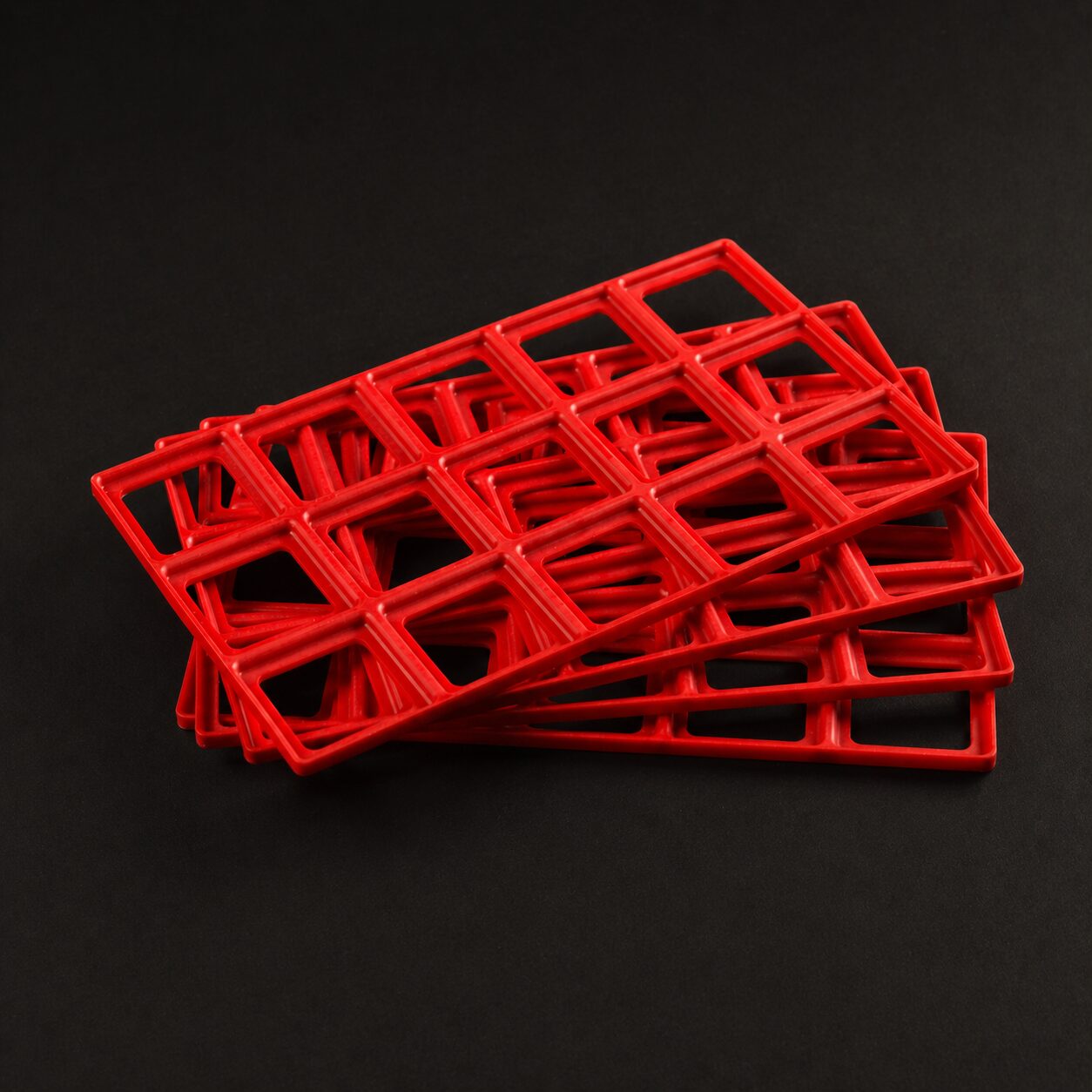 Stack of 4 Red Benchforma TPE Baseplates, indicating the shape and size of the product
